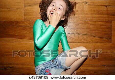 Stock Photo - Child on floor with fingers in mouth. Fotosearch