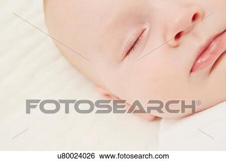Stock Photograph - Close up of baby in crib sleeping. Fotosearch