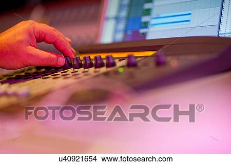 Picture - Close up of hand on mixing desk. Fotosearch