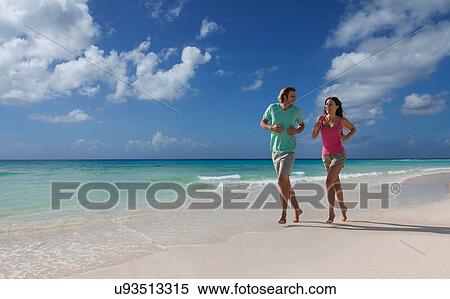 Stock Photography - Couple running on beach. Fotosearch