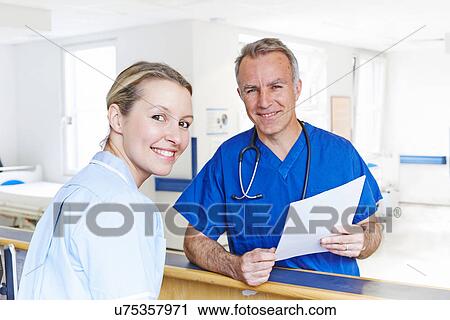 Stock Image - Doctor and nurse looking at camera. Fotosearch
