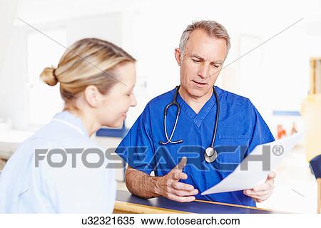 Stock Photography - Doctor and nurse looking at notes. Fotosearch