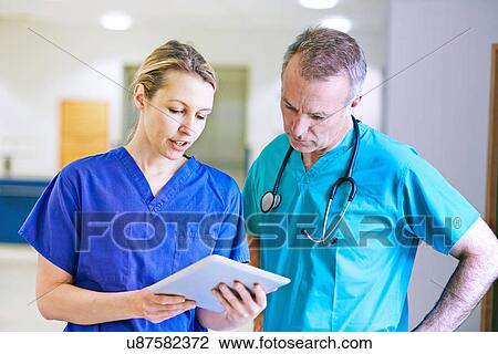 Doctor and surgeon looking at medical records View Large Photo Image Stock Image - Doctor and surgeon looking at medical records. Fotosearch