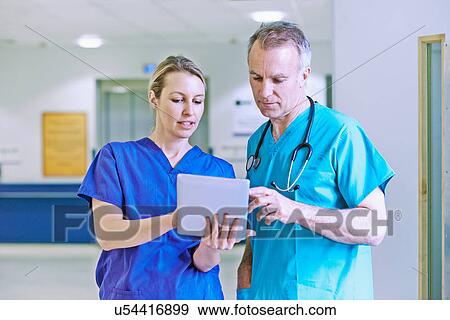 Doctor and surgeon looking at medical records View Large Photo Image Stock Photo - Doctor and surgeon looking at medical records. Fotosearch