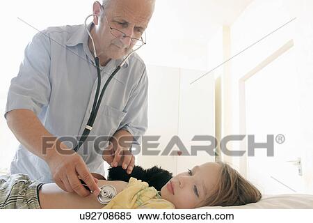 Doctor examining girl with stethoscope View Large Photo Image Stock Photography - Doctor examining girl with stethoscope. Fotosearch