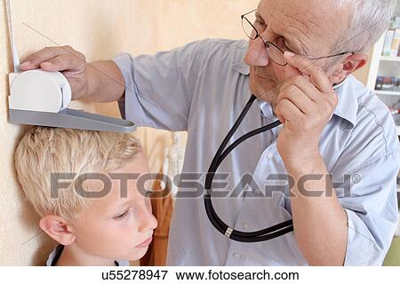 Doctor measuring boy's height View Large Photo Image Stock Photo - Doctor measuring boy's height. Fotosearch