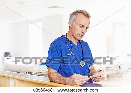Stock Image - Doctor reading notes. Fotosearch