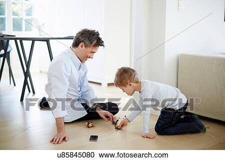 Stock Image - Father and son playing with toys. Fotosearch