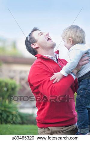 Stock Image - Father lifting toddler. Fotosearch