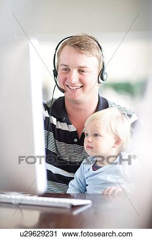 Stock Image - Father with baby boy using computer. Fotosearch