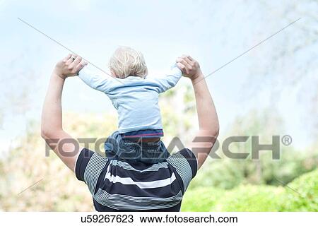Stock Image - Father with baby son on shoulders. Fotosearch