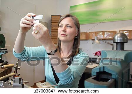 Female goldsmith taking measurements in workshop View Large Photo Image Stock Photo - Female goldsmith taking measurements in workshop. Fotosearch