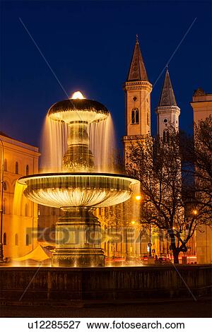 Stock Photo - Fountain in the Geschwister-Scholl-Platz and St. Ludwig's Church (Ludwigskirche) in the evening, Munich, Bavaria, Germany. Fotosearch