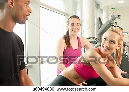 Stock Photograph - Friends chatting in gymnasium. Fotosearch