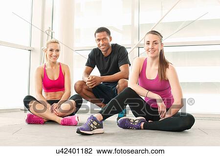Friends sitting on floor in gymnasium View Large Photo Image Stock Image - Friends sitting on floor in gymnasium. Fotosearch