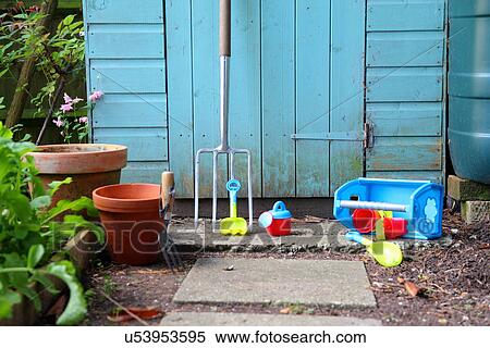 Gardening tools, pots and toys outside shed View Large Photo Image Stock Photography - Gardening tools, pots and toys outside shed. Fotosearch