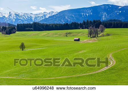 Stock Photo - German countryside with Alps in the background, Bavaria, Germany. Fotosearch