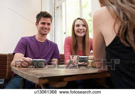 Group of friends chatting in cafe View Large Photo Image Stock Photo - Group of friends chatting in cafe. Fotosearch