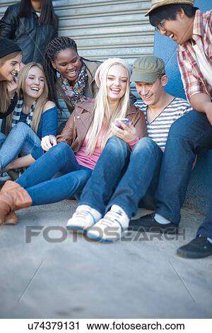Group of teenagers looking at mobile View Large Photo Image Stock Image - Group of teenagers looking at mobile. Fotosearch