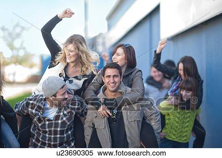 Group of young adults having piggy back race View Large Photo Image Stock Photography - Group of young adults having piggy back race. Fotosearch