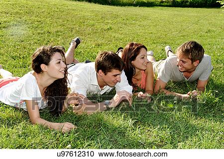 Group of young adults lying on the grass View Large Photo Image Stock Image - Group of young adults lying on the grass. Fotosearch