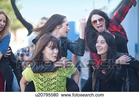 Stock Image - Group of young adults with arms raised. Fotosearch