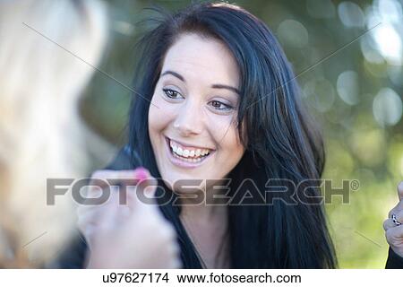 Picture - Group of young females sharing sweets. Fotosearch