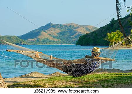 Stock Photography - Man in a hammock, Yasawa Island Group, Fiji, South Pacific Islands. Fotosearch