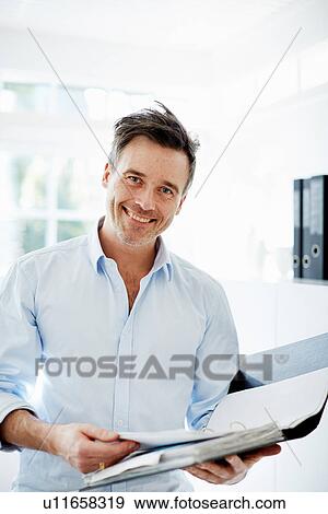 Stock Photo - Man looking at folder of paperwork. Fotosearch