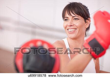 Mid adult woman training in gym View Large Photo Image Stock Photo - Mid adult woman training in gym. Fotosearch