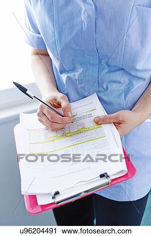 Mid-section of nurse writing paperwork View Large Photo Image Stock Image - Mid-section of nurse writing paperwork. Fotosearch