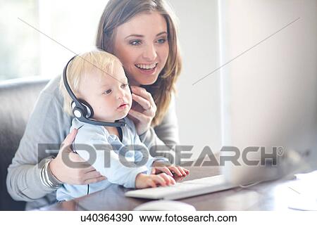 Mother and baby boy looking at computer screen View Large Photo Image Stock Image - Mother and baby boy looking at computer screen. Fotosearch