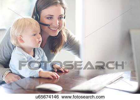 Mother and baby boy looking at computer View Large Photo Image Stock Photograph - Mother and baby boy looking at computer. Fotosearch