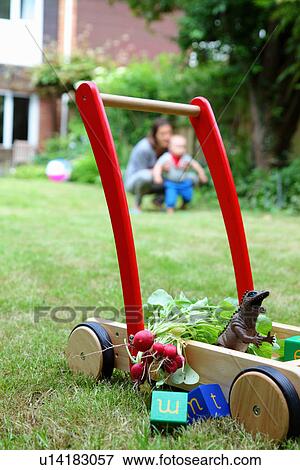 Mother and child with push cart and toys in garden View Large Photo Image Stock Photo - Mother and child with push cart and toys in garden. Fotosearch
