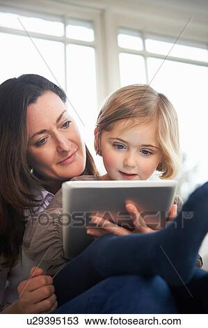 Mother and daughter using digital tablet View Large Photo Image Stock Image - Mother and daughter using digital tablet. Fotosearch