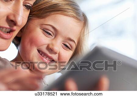 Stock Image - Mother and daughter using digital tablet. Fotosearch