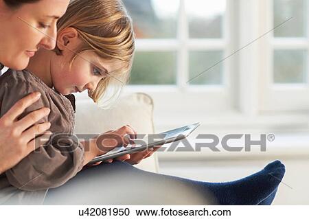 Mother and daughter using digital tablet View Large Photo Image Stock Image - Mother and daughter using digital tablet. Fotosearch
