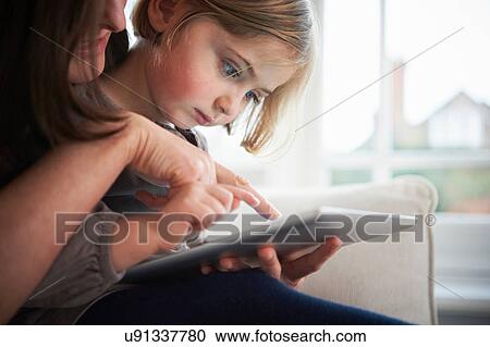 Mother and daughter using digital tablet View Large Photo Image Stock Image - Mother and daughter using digital tablet. Fotosearch