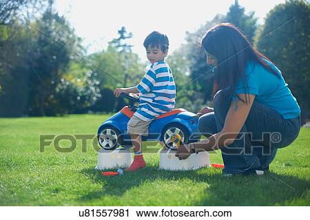Mother and son pretending to fix toy car View Large Photo Image Stock Image - Mother and son pretending to fix toy car. Fotosearch