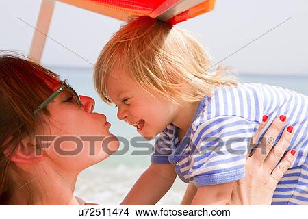 Picture - Mother kissing baby at beach. Fotosearch