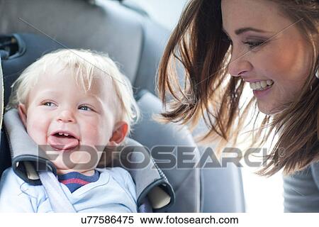 Mother with baby son in back seat of car View Large Photo Image Stock Photography - Mother with baby son in back seat of car. Fotosearch