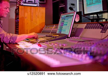 Stock Image - Music producer recording in studio. Fotosearch