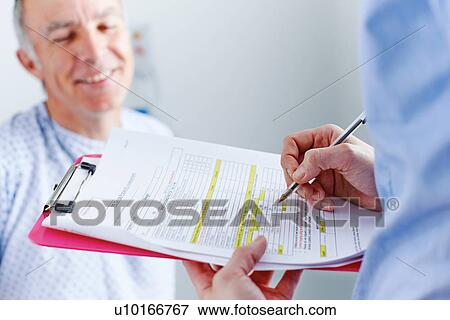 Nurse completing paperwork, patient in background View Large Photo Image Stock Photo - Nurse completing paperwork, patient in background. Fotosearch