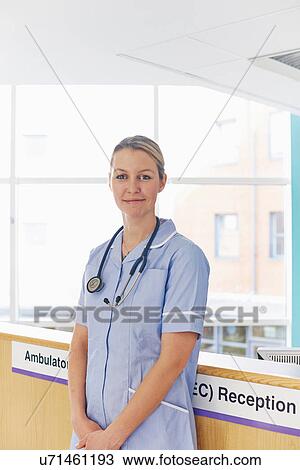 Nurse standing at reception desk View Large Photo Image Stock Image - Nurse standing at reception desk. Fotosearch