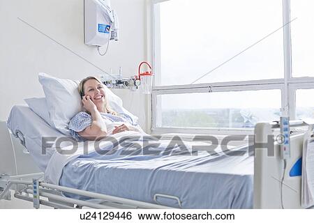 Patient lying on hospital bed on telephone call View Large Photo Image Stock Photograph - Patient lying on hospital bed on telephone call. Fotosearch