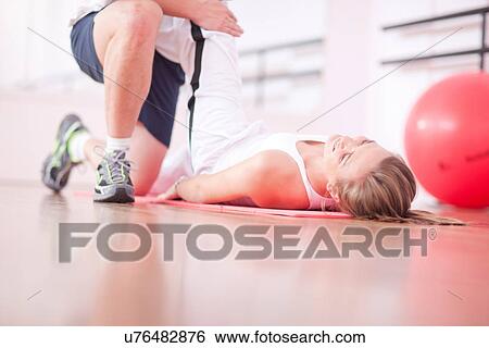 Stock Photograph - Personal trainer with client in gym. Fotosearch