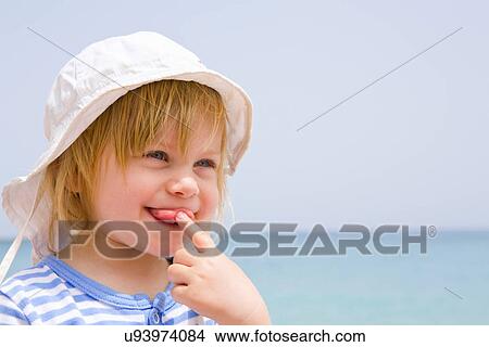 Picture - Portrait of baby at beach with tongue out. Fotosearch