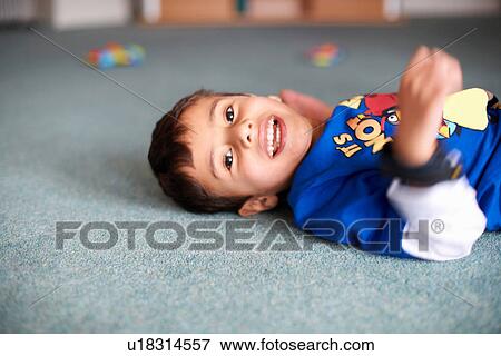 Portrait of boy lying on floor View Large Photo Image Stock Photo - Portrait of boy lying on floor. Fotosearch