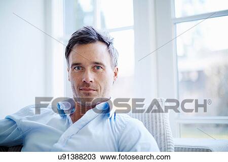 Stock Image - Portrait of businessman relaxing at home. Fotosearch