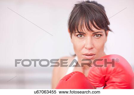 Stock Photography - Portrait of mid adult woman in boxing gloves. Fotosearch